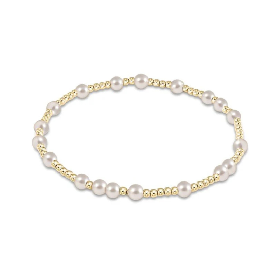 an image of a gold and pearl bead bracelet set against a white background 