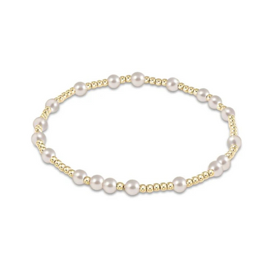 an image of a gold and pearl bead bracelet set against a white background 