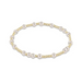 an image of a gold and pearl bead bracelet set against a white background 
