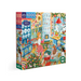 An image of a 1000 piece puzzle box set against a white background. The puzzle image is of a Scandinavian kitchen set during the holidays! It is bright and colorful, cozy, and full of holiday cheer with a cackling fireplace in the corner and a snowy winter scene out the window. 